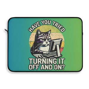 Op de afbeelding: Een groene en blauwe laptophuls met een retro-illustratie van een kat die aan een computer zit. De tekst luidt "Heb je geprobeerd om het uit en weer aan te zetten?"