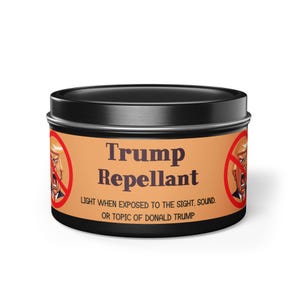 May include: A black tin can with a red circle and a diagonal line through it. The can has a label that says "Trump Repellant" and "Light when exposed to the sight, sound, or topic of Donald Trump."