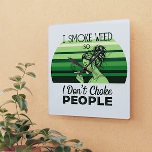 May include: Square wall clock with a white face featuring the text "I Smoke Weed So I Don't Choke People." The clock face has a green and white striped background with a green illustration of a person smoking.