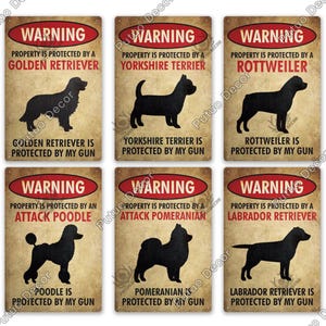 Pode incluir: Conjunto de seis placas de metal retangulares com acabamento envelhecido. Cada placa apresenta uma silhueta de cão e o texto "WARNING PROPERTY IS PROTECTED BY A" seguido do nome da raça e "PROTECTED BY MY GUN."