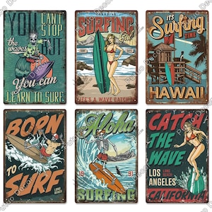 May include: Collection of vintage-style metal signs with surfing themes. Each sign features retro graphics of surfers, waves, and beach scenes. Text includes phrases like "Catch the Wave" and "Aloha Surfing."