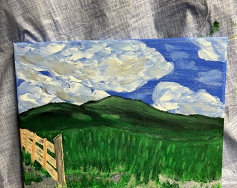 May include: A painting of a green grassy field with a wooden fence in the foreground. The background features a blue sky with white clouds and a green mountain range.