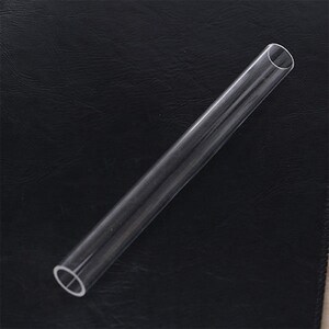 May include: A clear plastic tube with rounded ends. The tube is approximately 30 cm long and 2.5 cm in diameter.