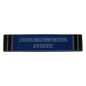 May include: Blue and black enamel pin with the text "Crisis Intervention Officer".