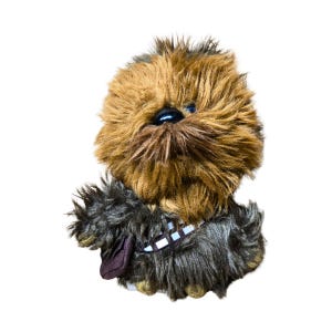 Op de afbeelding: Een Chewbacca pluche speelgoed uit Star Wars. Het speelgoed heeft bruin en zwart haar, een zwarte neus en blauwe ogen. Het heeft een bandolier met een bruin zakje en een wit en bruin riempje.