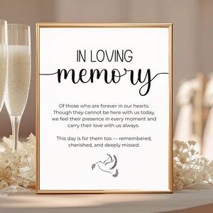 May include: A framed sign with the words "IN LOVING memory" in black script. The sign includes a message about remembering loved ones, with a dove illustration at the bottom. The frame is gold.