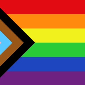 Op de afbeelding: Een regenboogvlag met een zwarte, bruine, lichtblauwe en roze chevron aan de linkerkant en de traditionele regenboogstrepen aan de rechterkant.
