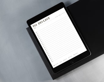 Puede incluir: Una tableta negra con una aplicación de lista de tareas blanca abierta. La aplicación tiene un título que dice "TO DO LIST" y una sección para la fecha. La lista tiene casillas de verificación y líneas para escribir tareas. La tableta está sobre una superficie negra.