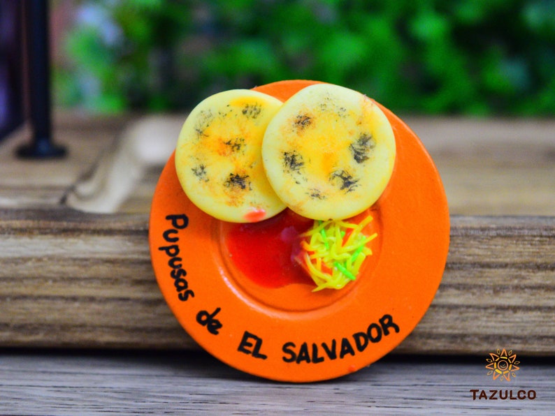 🫓🔥 Magneto de Pupusas – Sabor y Tradición Salvadoreña 🇸🇻

Decora tu hogar con este magneto artesanal de pupusas, hecho en porcelana fría con detalles realistas que capturan la esencia del platillo más icónico de El Salvador. 🌟 Su diseño recrea el dorado perfecto de una pupusa recién hecha, evocando su delicioso aroma y sabor casero. Ideal para coleccionistas y amantes de la cultura salvadoreña.
