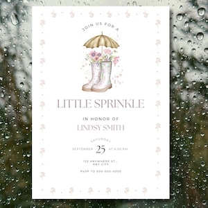 Puede incluir: Una tarjeta de invitación rosa claro con el texto "JOIN US FOR A LITTLE SPRINKLE" y detalles para un baby shower. La tarjeta presenta una ilustración de botas de agua, flores y un paraguas. La fecha es el 25 de septiembre.