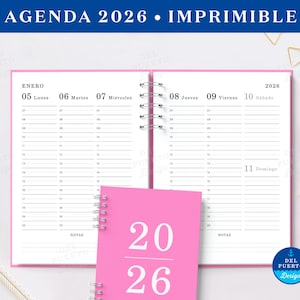 May include: A pink 2026 agenda with a spiral binding, open to a weekly spread. The cover of the agenda is visible, displaying the numbers "2026" in a bold font. The top banner reads "AGENDA 2026 • IMPRIMIBLE".