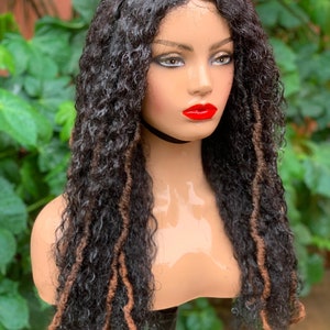 May include: A long, curly, black and brown wig with dreadlocks. The wig is on a mannequin head.