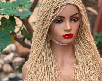 May include: A blonde human hair wig with long, thin dreadlocks. The wig is styled in a straight, parted style. The wig is on a mannequin head.