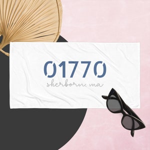 Puede incluir: Toalla de playa blanca con texto azul que dice "01770 sherborn, ma".