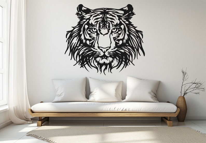 May include: Black and white silhouette of a tiger's face on a white wall, with a white couch in the foreground.