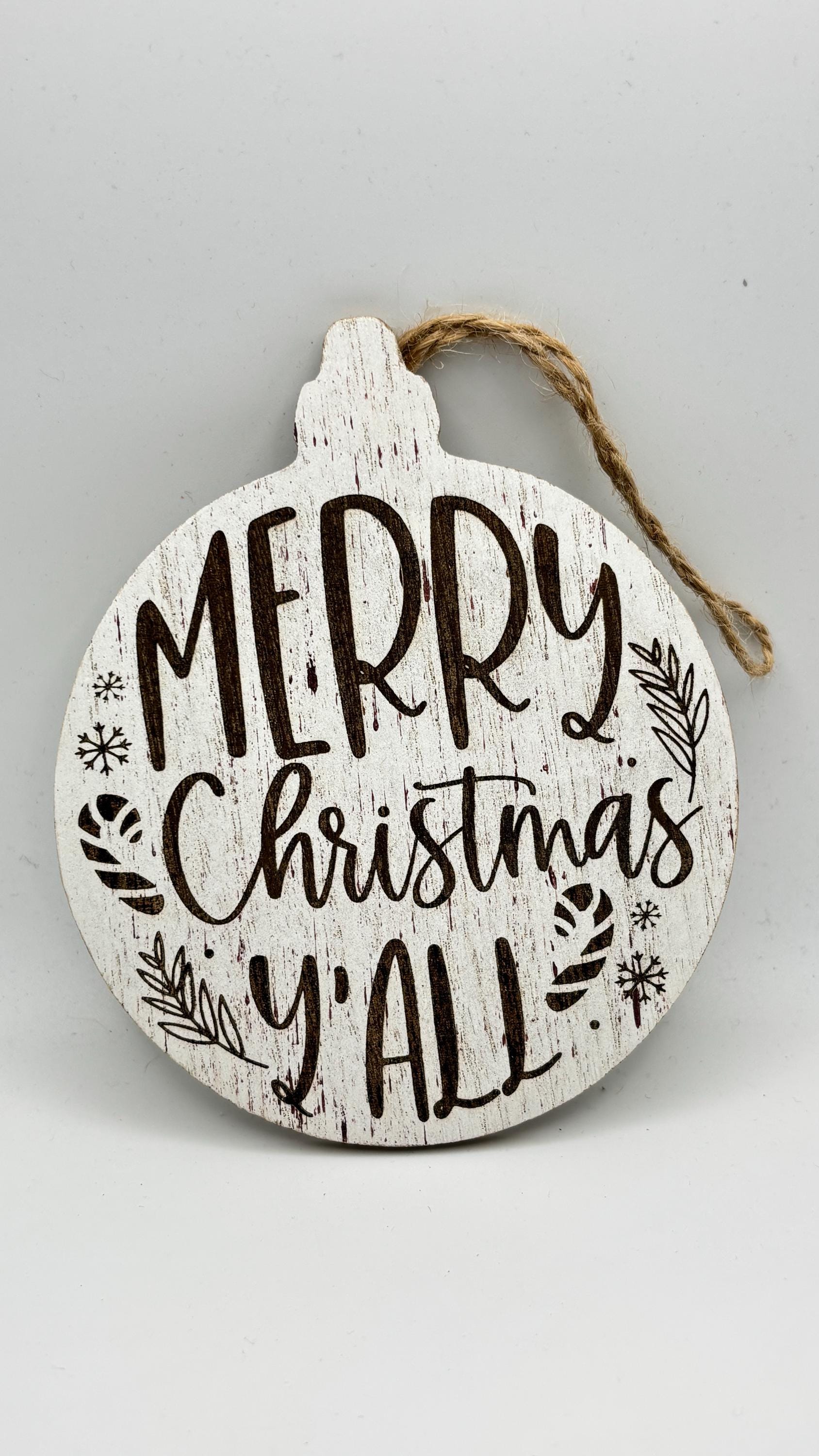 A flat view of a circular wooden MDF ornament engraved with Merry Christmas Yall and festive accents.