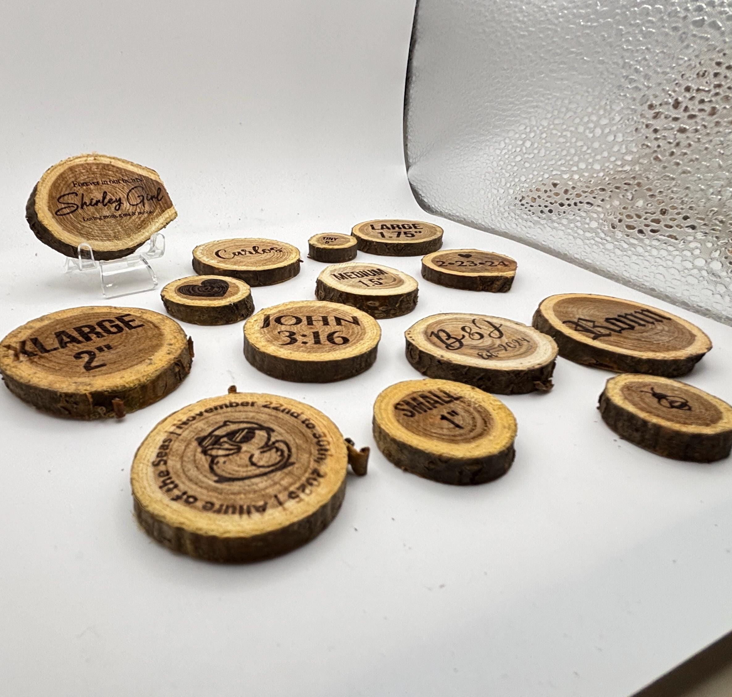An assortment of custom engraved wood slices of various sizes displayed against a white background.