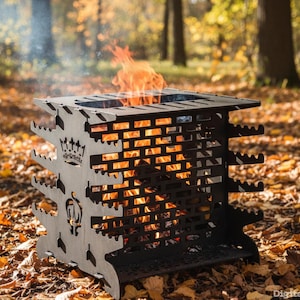 Könnte beinhalten: Ein schwarzer Metall-Feuerkorb mit Kronen- und Emblemdesign, gefüllt mit Flammen. Der Feuerkorb hat eine quadratische Form mit ausgeschnittenen, ziegelartigen Mustern an den Seiten. Die Flammen sind hellorange und gelb. Der Feuerkorb befindet sich im Freien, umgeben von Herbstlaub.