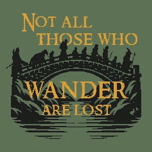 May include: A cross-stitch design on a green background features the text "NOT ALL THOSE WHO WANDER ARE LOST" in yellow. Below the text is a bridge with silhouettes of figures, suggesting a fantasy theme.