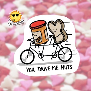 May include: A tan and white bread slice and a peanut butter jar are riding a tandem bicycle. The bread slice is smiling and has arms and legs. The peanut butter jar has a smiling face and a peanut on its front. The bicycle has black wheels and a black frame. The text "You drive me nuts" is written below the bicycle.