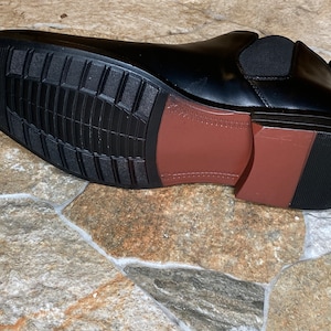Puede incluir: Bota Chelsea de cuero negro con suela marr&oacute;n y suela exterior de goma negra. La suela tiene un patr&oacute;n texturizado para agarre. La bota incluye un panel lateral el&aacute;stico. Una opci&oacute;n de calzado cl&aacute;sica y vers&aacute;til.