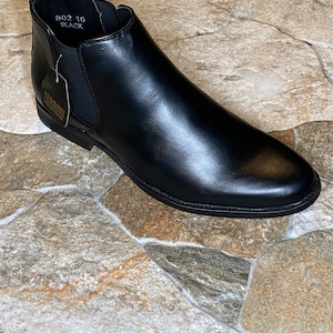 Puede incluir: Bota Chelsea de cuero negro con punta redondeada. La bota tiene una leng&uuml;eta en la parte trasera y paneles laterales el&aacute;sticos. La etiqueta dice "TERRONI". Talla 10.