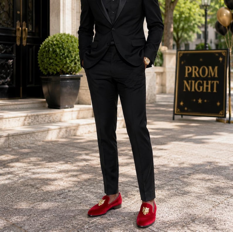 May include: A person in a black suit and red velvet loafers with gold accents. The sign in the background reads "PROM NIGHT". The outfit is formal and suitable for a special occasion.