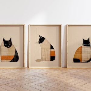 Pu&ograve; includere: Tre stampe incorniciate di gatti stilizzati in bianco e nero con motivi geometrici in arancione e beige. I gatti sono in pose diverse, uno seduto, uno rannicchiato e l'ultimo che guarda di lato.