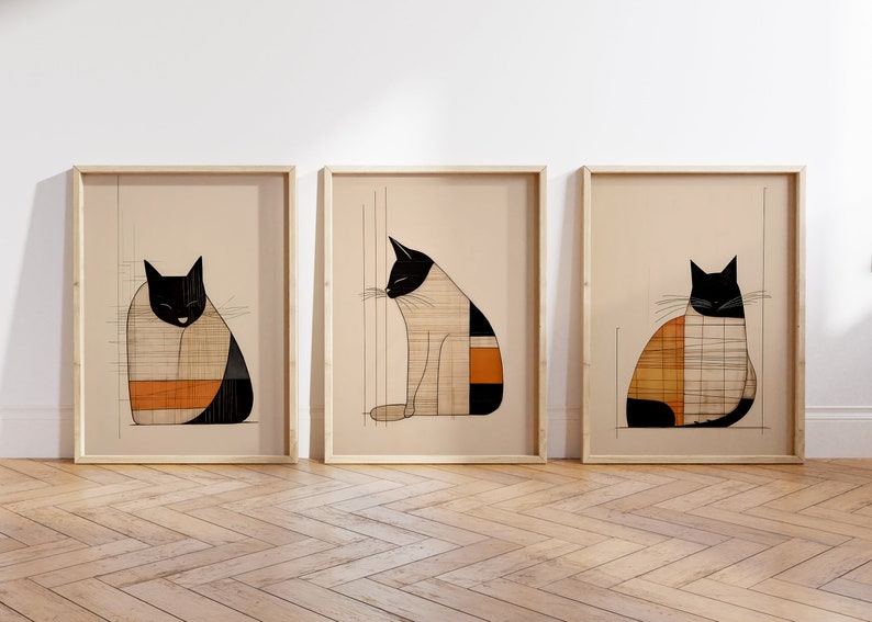 Pu&ograve; includere: Tre stampe incorniciate di gatti stilizzati in bianco e nero con motivi geometrici in arancione e beige. I gatti sono in pose diverse, uno seduto, uno rannicchiato e l'ultimo che guarda di lato.