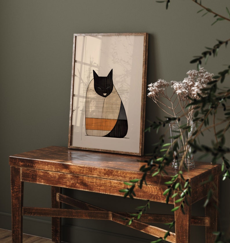 Pu&ograve; includere: Un'illustrazione incorniciata di un gatto nero con un motivo a strisce bianche e arancioni sul corpo. Il gatto &egrave; seduto su un tavolo di legno marrone chiaro con un vaso di fiori bianchi sullo sfondo.