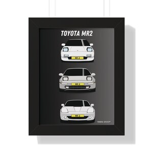 May include: A framed print featuring a black and white illustration of three generations of Toyota MR2 sports cars. The cars are shown from the front, with the text "TOYOTA MR2" and "1985-2007" at the top and bottom of the image.