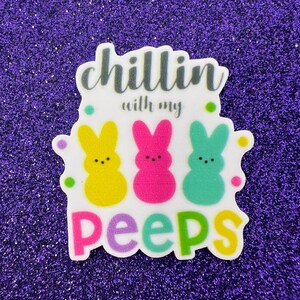 Może przedstawiać: Biała naklejka z tekstem "Chillin with my Peeps" w kolorze czarnym, fioletowym i zielonym. Na naklejce znajdują się trzy żółte, różowe i niebieskie kreskówkowe Peeps.