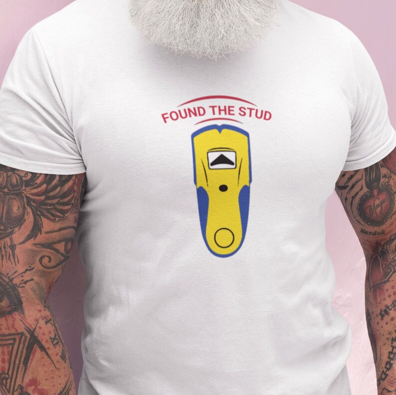 May include: White t-shirt with a blue and yellow stud finder illustration and the text "FOUND THE STUD" in red.