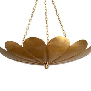 May include: A brass-colored, petal-shaped chandelier with a central pendant. The light fixture is suspended by three chains. The design features overlapping, curved elements, creating a floral appearance. The overall aesthetic is elegant and modern.
