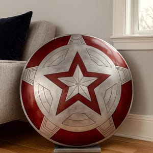 May include: A large, round shield with a red, white, and silver color scheme. The shield features a prominent five-pointed star in the center, surrounded by a circular design. It is displayed on a silver stand.