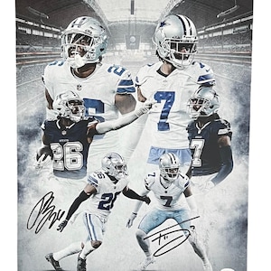 May include: A black and white photo of five Dallas Cowboys football players in their uniforms. The players are posed in a dynamic, action-filled composition. The photo is signed by the players, with the signatures in black ink.