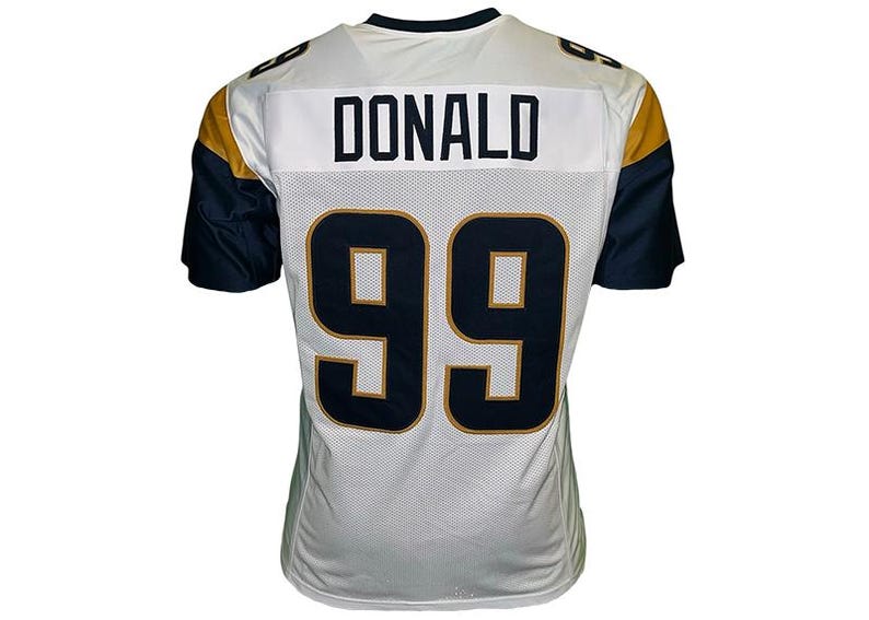 May include: White football jersey with navy blue and gold accents. The jersey features the name "DONALD" across the upper back and the number "99" in navy blue with gold trim. The sleeves are navy blue.