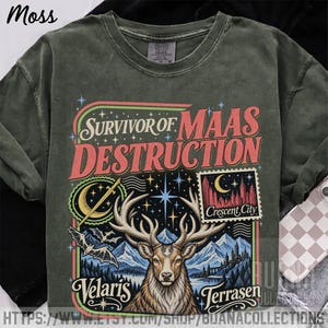 Może przedstawiać: Koszulka w kolorze mchu z nadrukiem graficznym zawierającym tekst "Survivor of Maas Destruction", "Crescent City", "Velaris" oraz "Terrasen". Wzór przedstawia centralnie umieszczoną głowę jelenia, góry, nietoperze, miecz oraz półksiężyc.