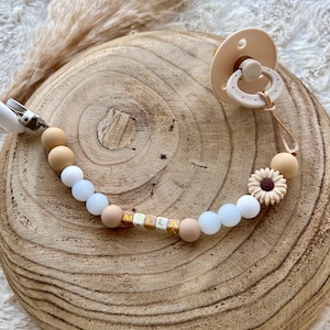 Personalized pacifier clip for baby girl in beige color, small white fluorescent beads, gold thread