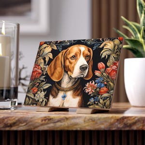 May include: A framed print featuring a brown and white beagle dog with a blue collar and a flower charm. The dog is surrounded by a floral pattern with red, blue, and yellow flowers on a black background.