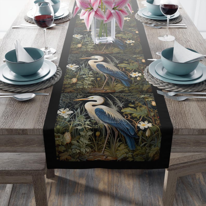 A William Morris inspired table runner featuring the graceful heron (or egret). This elegant piece brings botanical wildlife art to life, perfect for elevating your table setting and enhancing your dining room decor with nature-inspired design.