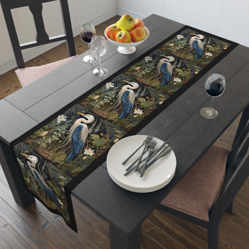 A William Morris inspired table runner featuring the graceful heron (or egret). This elegant piece brings botanical wildlife art to life, perfect for elevating your table setting and enhancing your dining room decor with nature-inspired design.