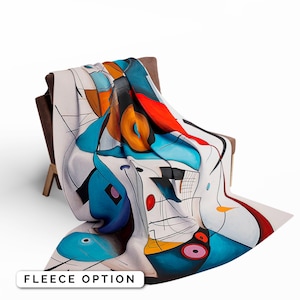 May include: A fleece blanket with an abstract design featuring geometric shapes in shades of blue, red, yellow, and white. The blanket is folded and draped over a chair.