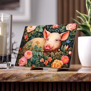 May include: A pink piglet lies in a bed of colourful flowers. The piglet has a pink snout and is surrounded by green leaves and pink, yellow, and orange flowers.