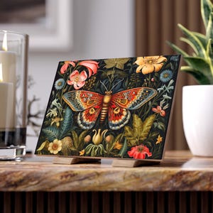 Puede incluir: Una mariposa colorida con alas rojas, naranjas y negras está rodeada de una variedad de flores y hojas sobre un fondo oscuro. La mariposa está en el centro de la imagen y es el foco principal.