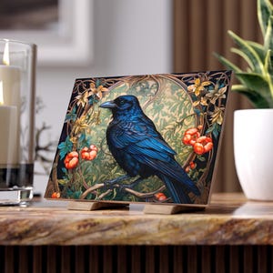 May include: A blue crow perched on a branch with red berries and green leaves. The crow is surrounded by a decorative floral pattern in shades of green, gold, and brown.