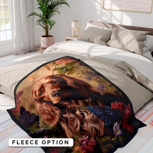 Può includere: Una coperta in pile con un cane marrone e bianco a pelo lungo, circondato da fiori e viti colorati. La coperta ha un bordo nero e le parole "Fleece Option" sono stampate in bianco in basso.