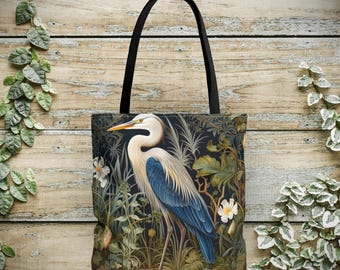 Könnte beinhalten: Eine schwarze Tragetasche mit einem weißen Reiher, der in einem üppigen grün-blauen Blumenmuster steht. Der Reiher hat einen langen, dünnen Schnabel und lange, schlanke Beine. Die Tasche hat schwarze Henkel.