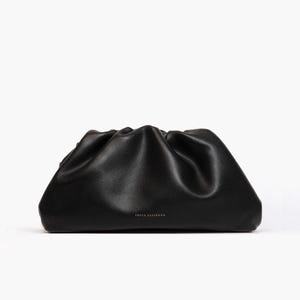 Peut inclure: Une pochette en cuir noir avec un design souple, froncé et plissé sur le dessus. L'avant du sac présente le texte FREYA ESTEPHAN imprimé en petites lettres capitales blanches centrées près du bord inférieur de la surface lisse et mate.