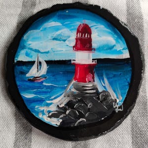 Red lighthouse and sailing ship